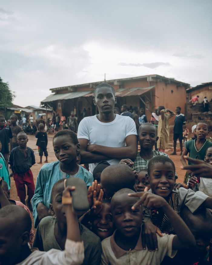 A dynamic scene of children and adults in a vibrant village setting in Nigeria.